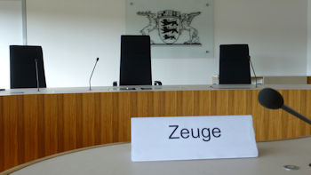 Foto der Richterbank  im Sitzungssaal des Landesarbeitsgerichts Baden-Württemberg mit dem Landeswappen im Hintergrund